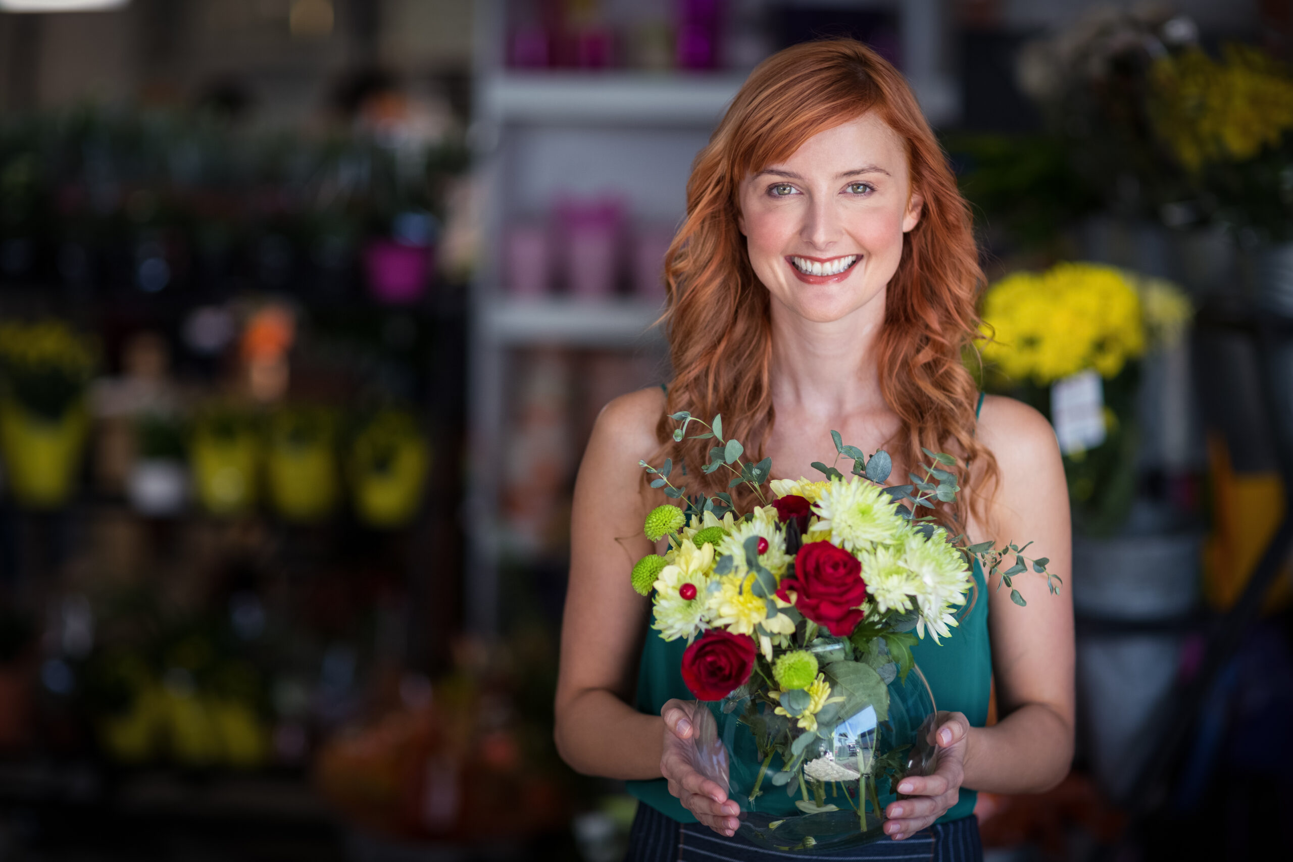 Portrait of female florist holding flower vase at flower shop